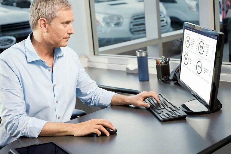 A man seated and using a desktop computer