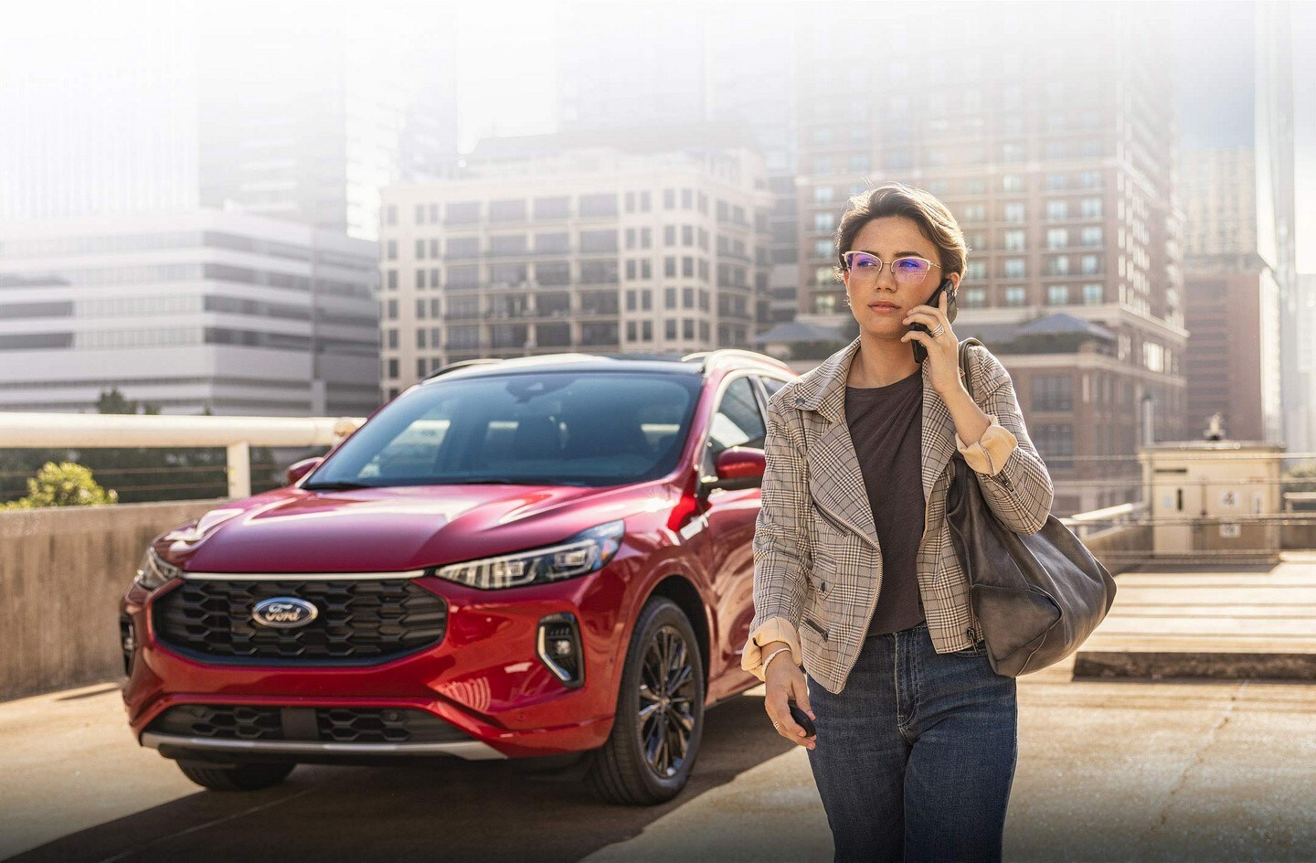 A 2023 Ford Escape® parked with a woman walking talking on cell phone