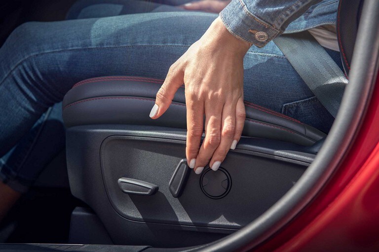 Close-up of a woman's hand operating the driver's seat controls
