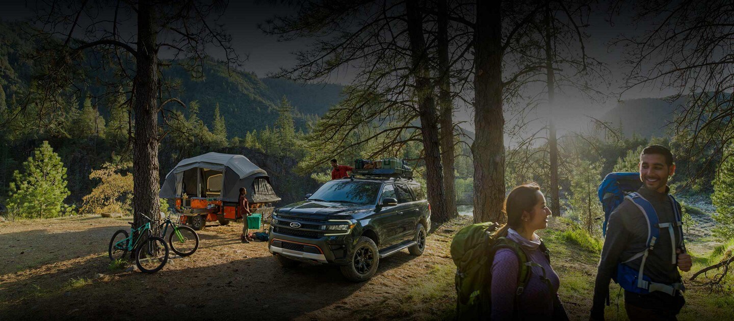 Side by side shots of a 2023 Ford Expedition SUV being driven down a dirt road and parked at a campsite