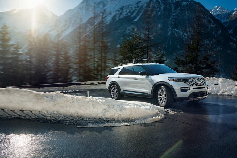 2023 Ford Explorer® SUV being driven on a winding road flanked by snow banks