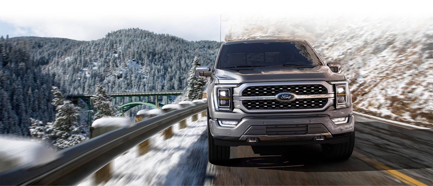 Front view of a 2023 Ford F-150® being driven on a snowy mountain roadway