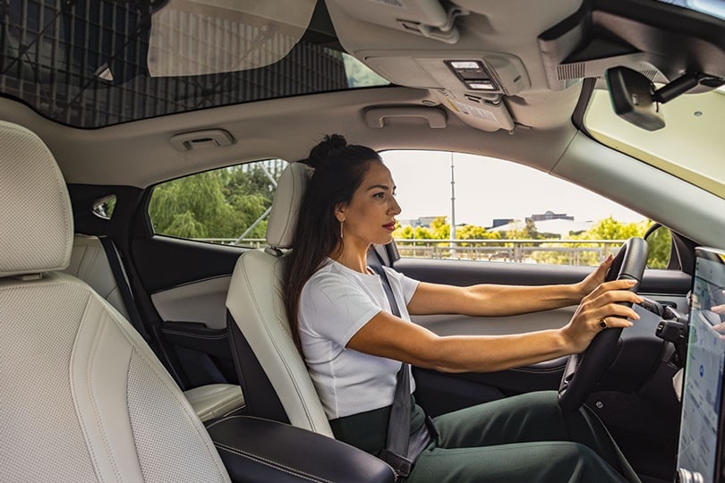 Interior view of a woman driving a 2023 Mustang Mach-E SUV