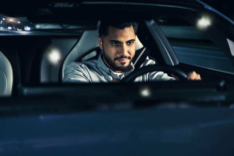 Person sitting in the driver’s seat of a parked 2024 Ford Mustang® coupe