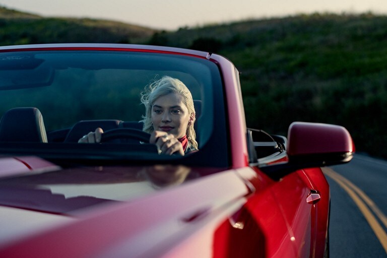 Person driving a 2024 Ford Mustang® convertible model on a highway