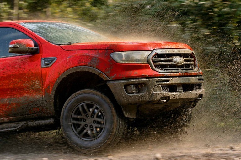 2023 Ford Ranger® with the Tremor Off-Road Package in Hot Pepper Red driving through mud