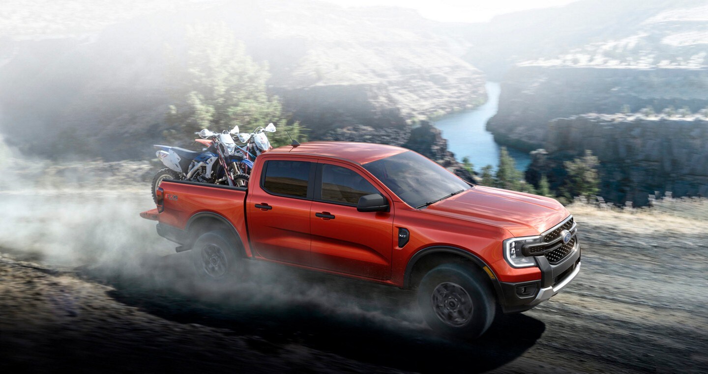 A 2024 Ford Ranger® is hauling dirt bikes being driven off-road