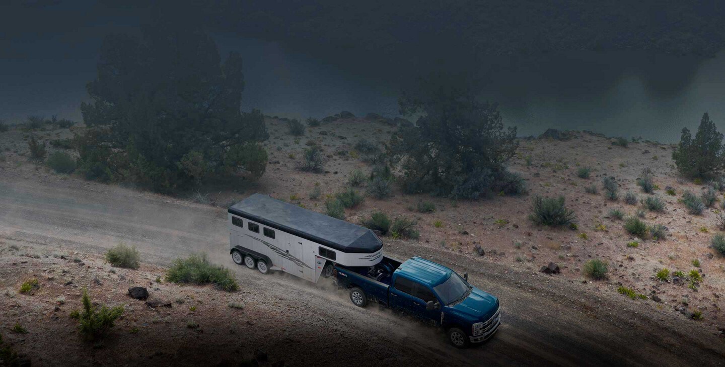 2023 Ford Super Duty® F-250® pulling a camper trailer on mountain road