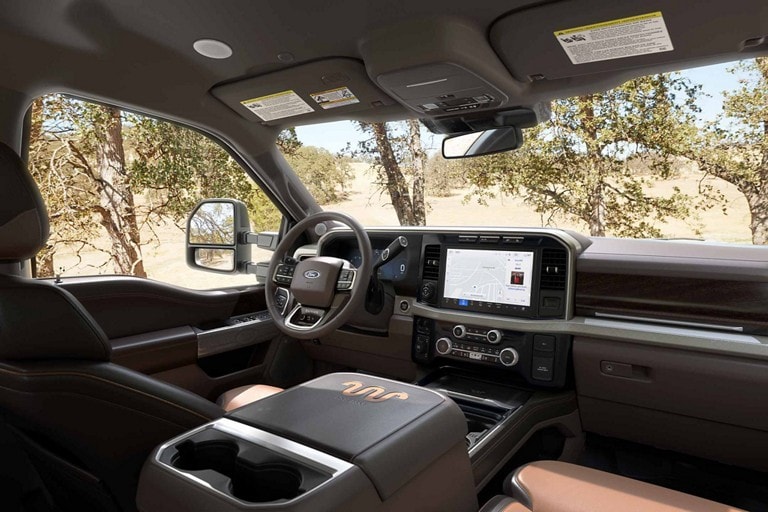 Front interior of a 2023 Ford Super Duty® King Ranch™ pickup with Baja-coloured leather seating surfaces