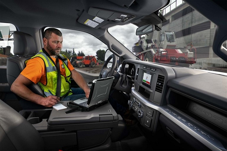 Person using a laptop computer inside a 2025 Ford Super Duty® XL pickup