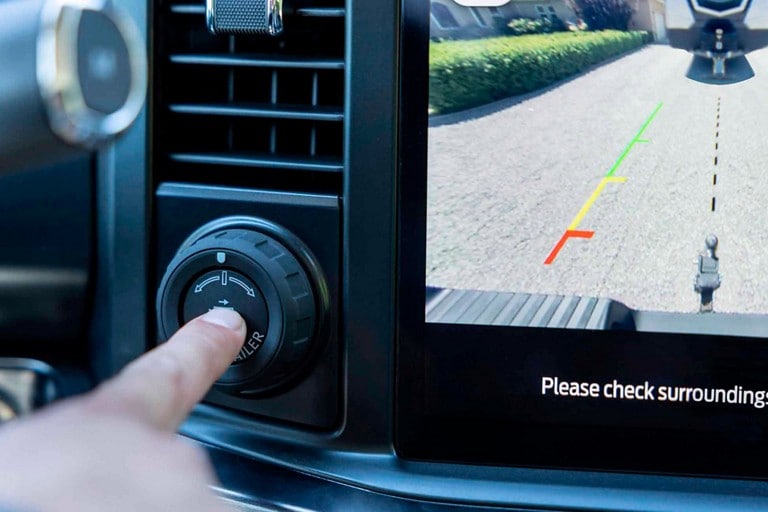 Close-up of a hand pressing the Pro Trailer Hitch Assist™ button