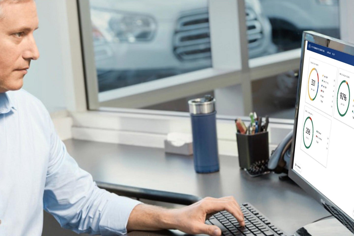 A businessman sitting at his computer reviewing Telematics information
