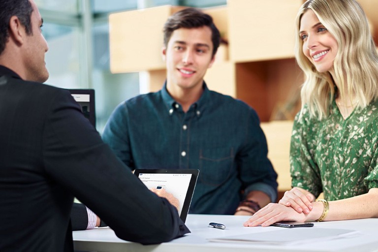 A couple consults with a salesperson at a Ford dealership