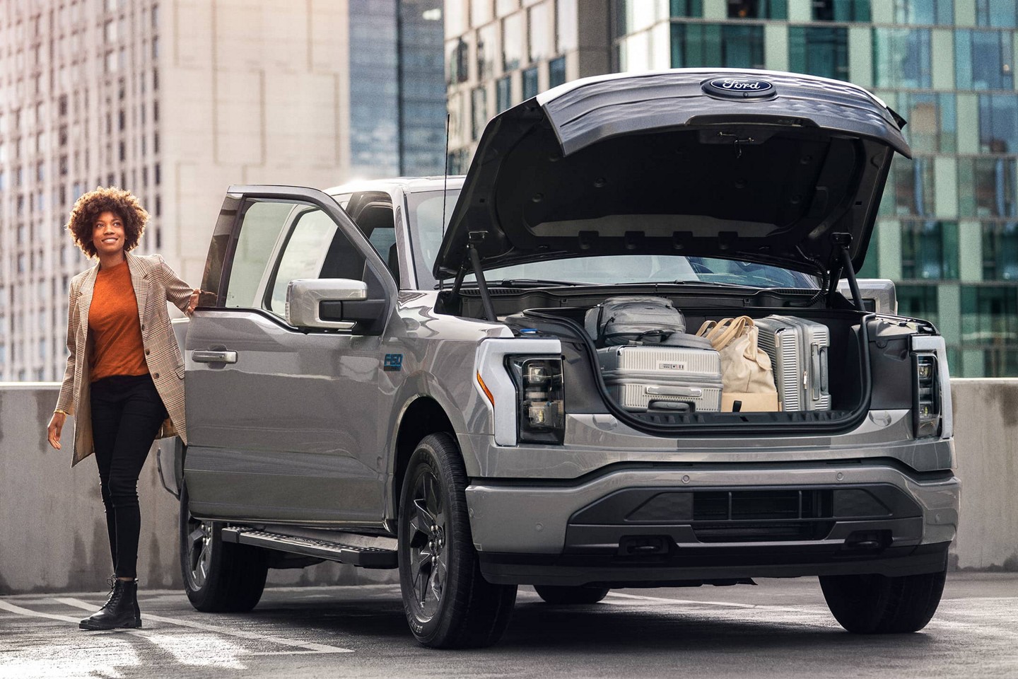 Parked F-150 Lightning with an open frunk full of luggage.