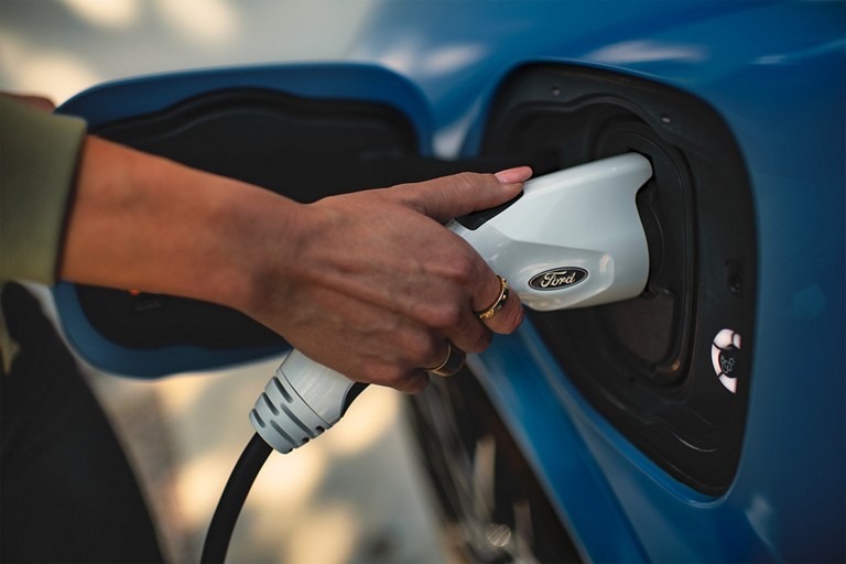 Person plugging in a Ford EV.