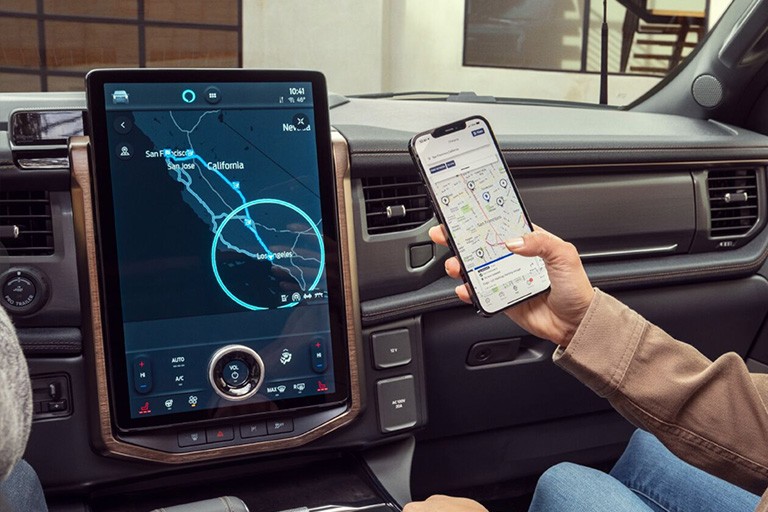 A person uses the FordPass app on their phone in conjunction with SYNC 4 in-vehicle
