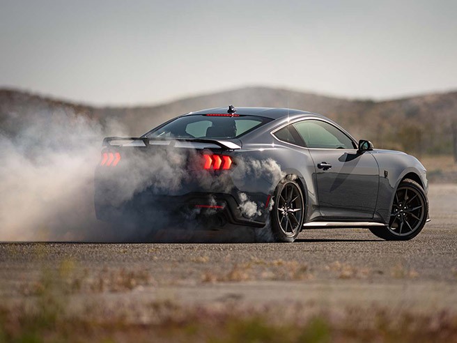 A Mustang® Dark Horse™ coupe smoking tires on desert pavement