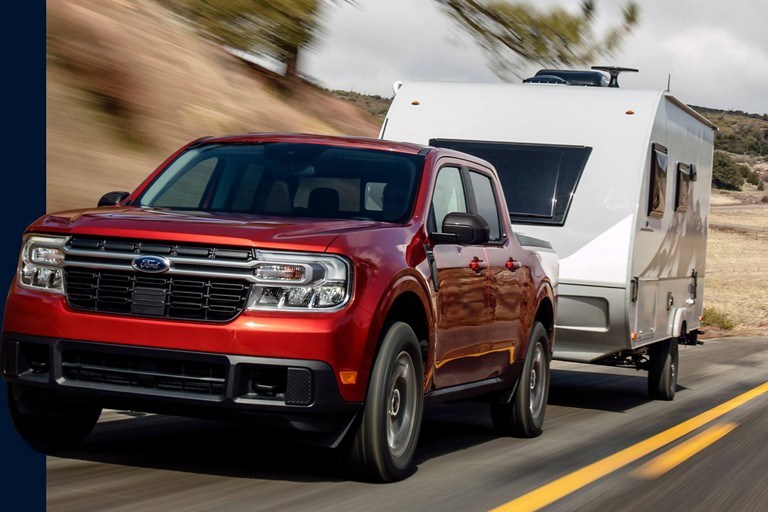 F-150 towing a trailer on a two-lane highway.