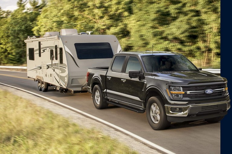 A Ford F-150 towing an RV.
