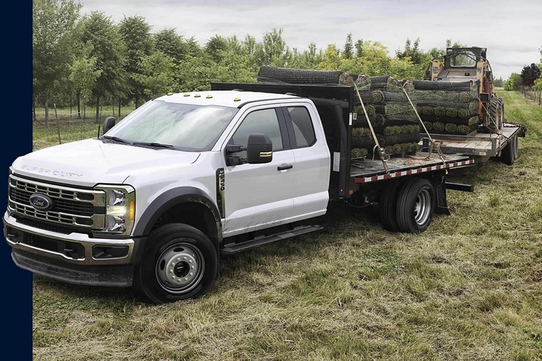 A Super Duty Chassis Cab truck hauling heavy equipment.