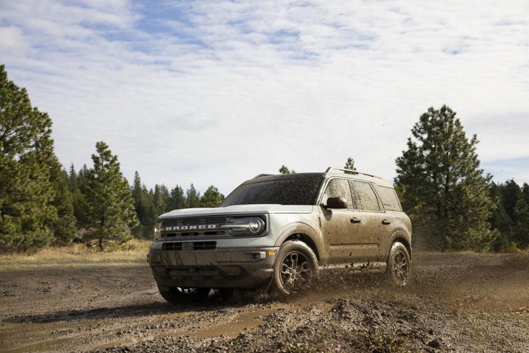 A Ford Bronco Sport drives through muddy terrain