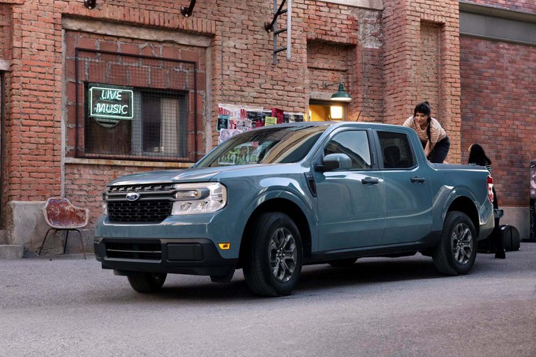 A blue Ford Maverick parked on a city street