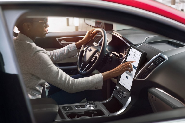 A woman operates the 12 inch touchscreen in a Ford Edge