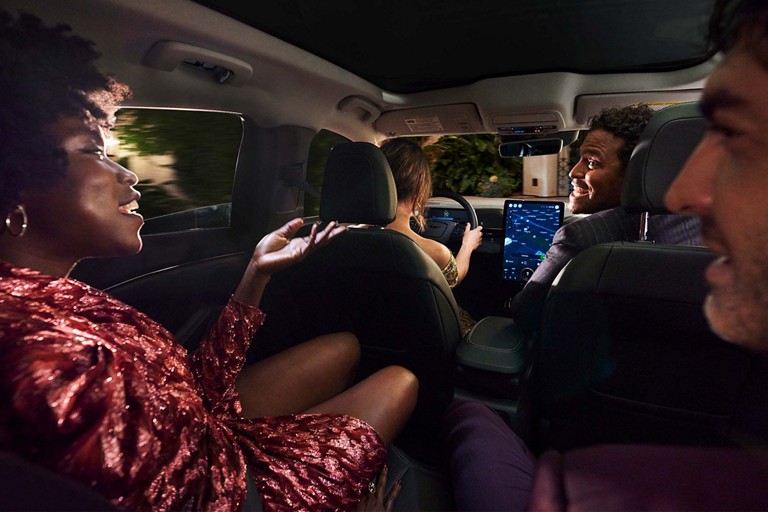 Three passengers chat happily in a Ford vehicle.