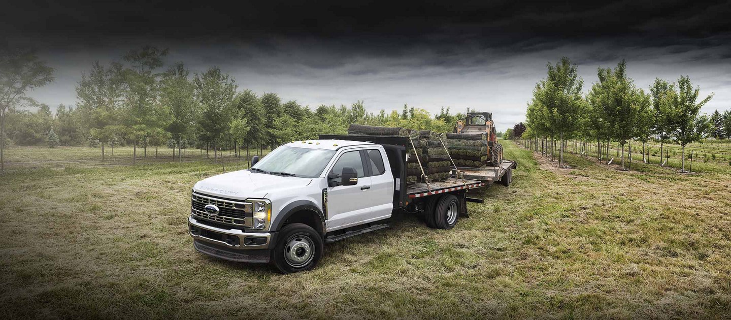 A 2025 Ford Super Duty® F-450® XLT hauling solid and towing a Bobcat