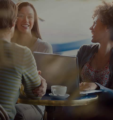 Three women sitting at a table enjoying conversation