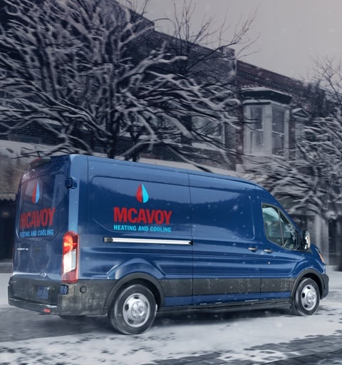 2020 Ford Transit Cargo Van in Blue Jeans color with custom branding being driven on snowy street during storm