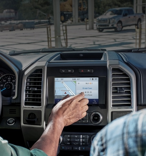 Construction workers inside parked 2020 Ford F 1 50 accessing navigation screen on center console