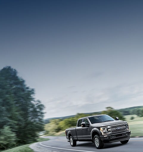 Super Duty Driving Along A Tree-Lined Highway. Offer Shown.
