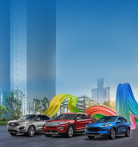 Edge, Explorer, and Escape driving along a road with coloured ribbons trailing the vehicles. Offer copy reads: The Ford Year-End Event. Get Great Rebates On Most New 2020 Models