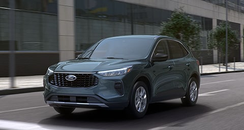 2020 Ford Transit Passenger Van in Kapoor Red being driven on a snowy residential street. 