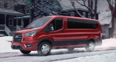 2020 Ford Transit Passenger Van in Kapoor Red being driven on snowy residential street