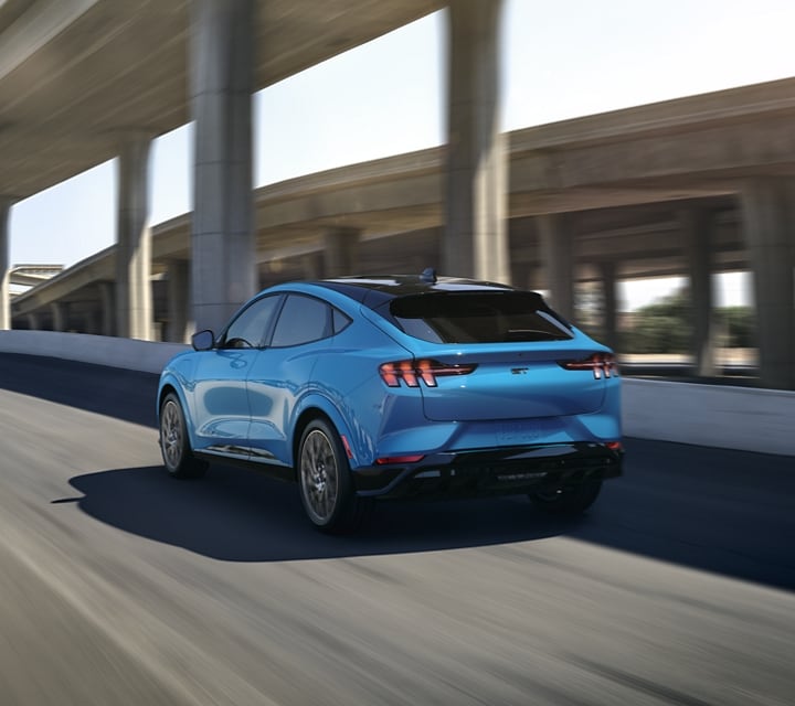 2021 Ford® Mustang Mach-E GT in Grabber Blue Metallic being driven on a freeway