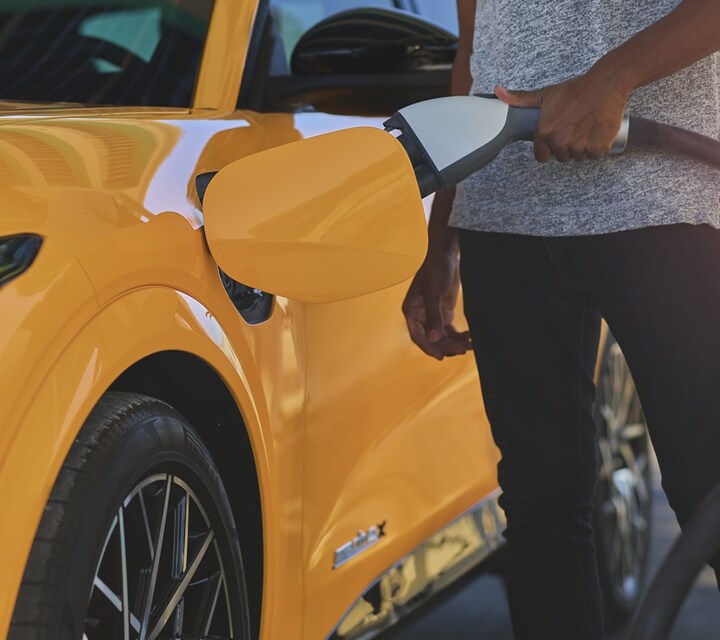 A person charging their 2021 Ford® Mustang Mach-E at a public charging station