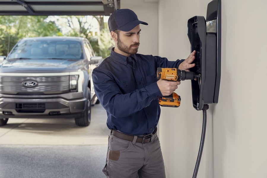 Service technician installing a home charger in a residential garage.