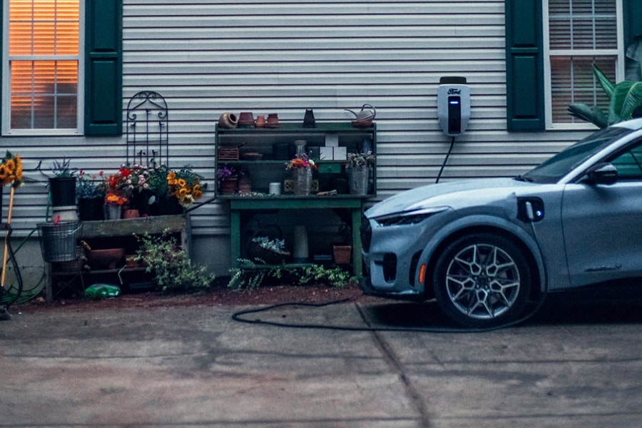 A 2024 Mustang Mach-E being charged outside the house. 