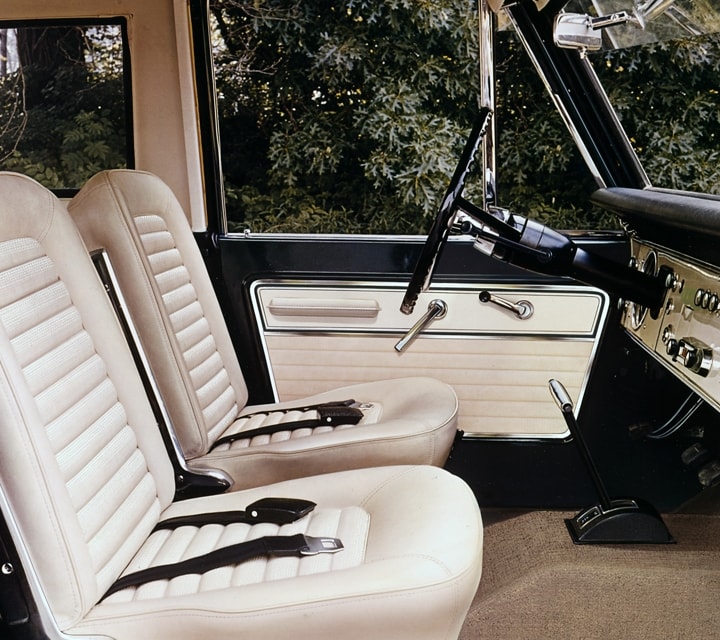 A 1967 Ford Bronco Sport interior with Parchment Vinyl driver and passenger bucket seats