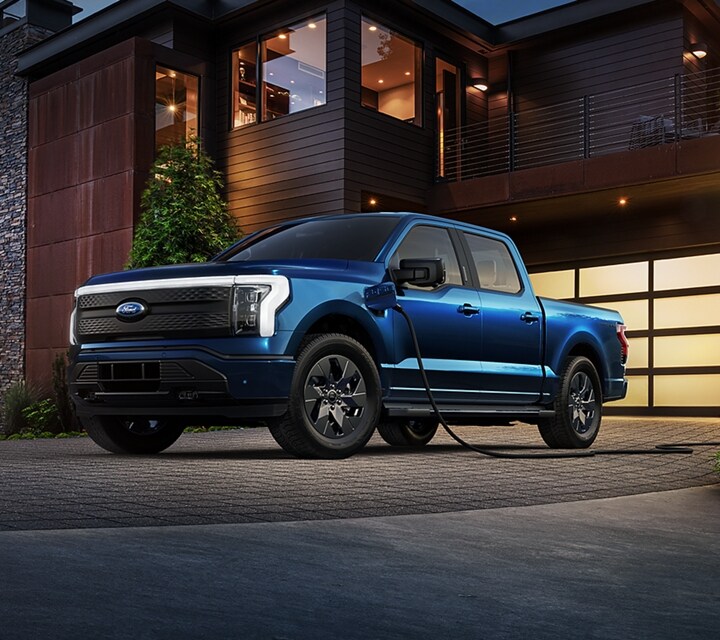 2023 Ford F-150® Lightning™ in Atlas Blue hooked up to a home charger