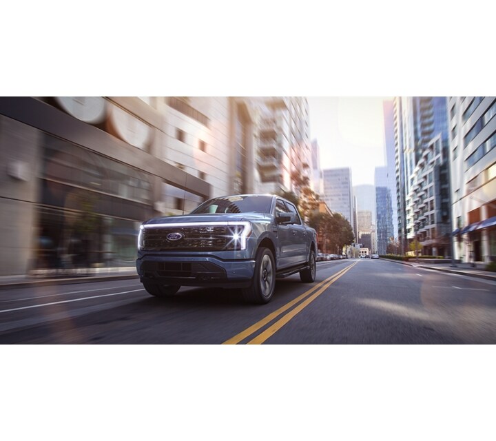 A 2023 Ford F-150® Lightning™ being driven in an urban environment