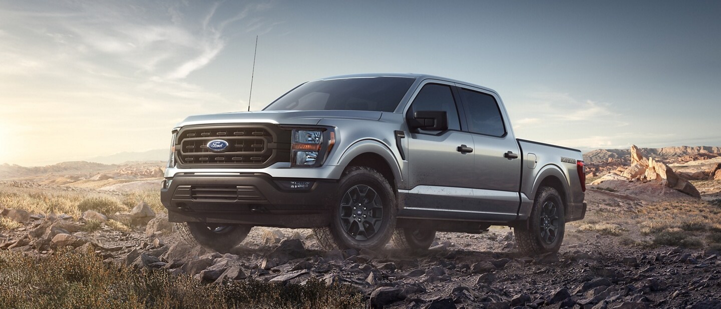 2023 Ford F-150® Rattler™ in Iconic Silver being driven over a rocky mountain terrain