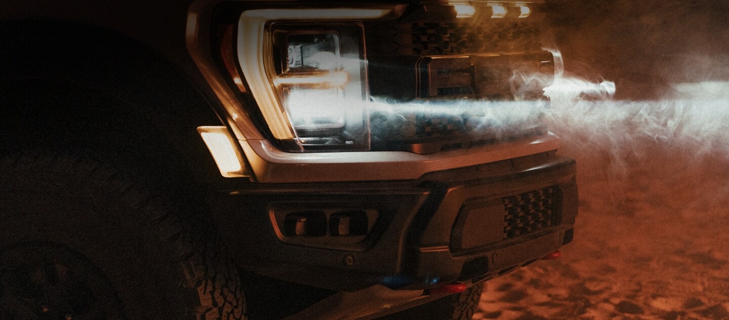 Close-up on the headlamps of the 2023 Ford F-150® Raptor® R with dust blowing