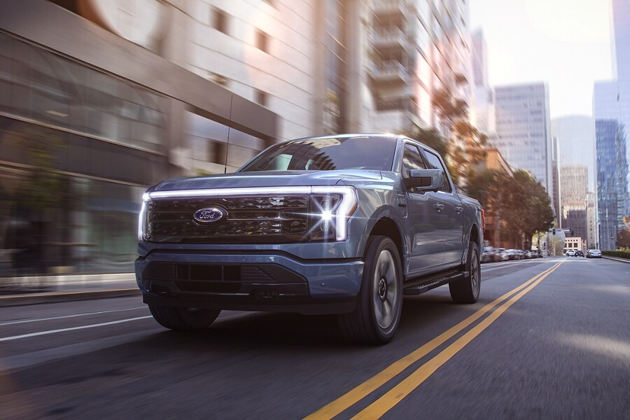 2022 Ford F-150® Lightning™ in Iced Blue Silver being driven in the city