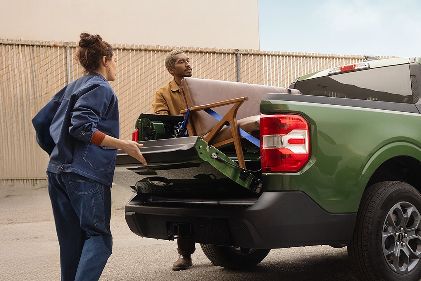 Two people load the truck bed of a Ford Maverick.