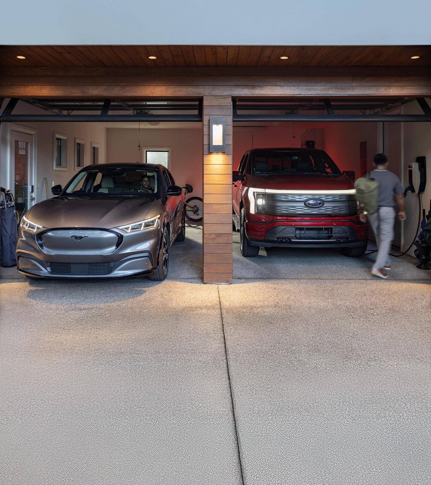 A Mustang Mach-E® and F-150 Lightning® parked side by side in a residential garage