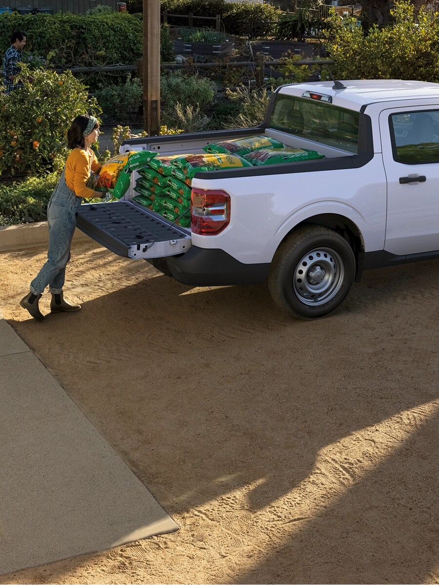 Two people load a Maverick truck bed.