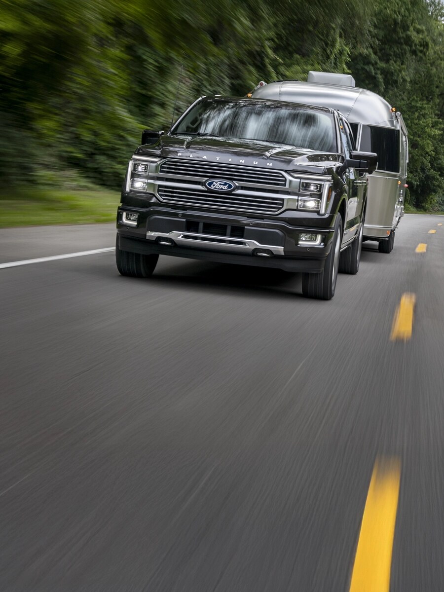 F-150 towing a trailer on a two-lane highway.